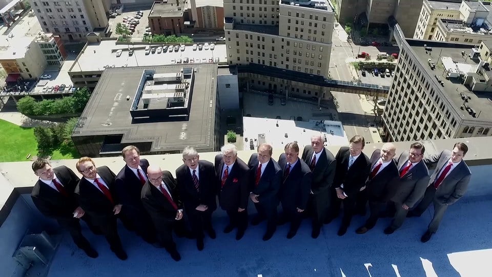 Slater & Zurz website design: a frame from the 2017 homepage video, the attorneys on the roof with downtown Akron around them