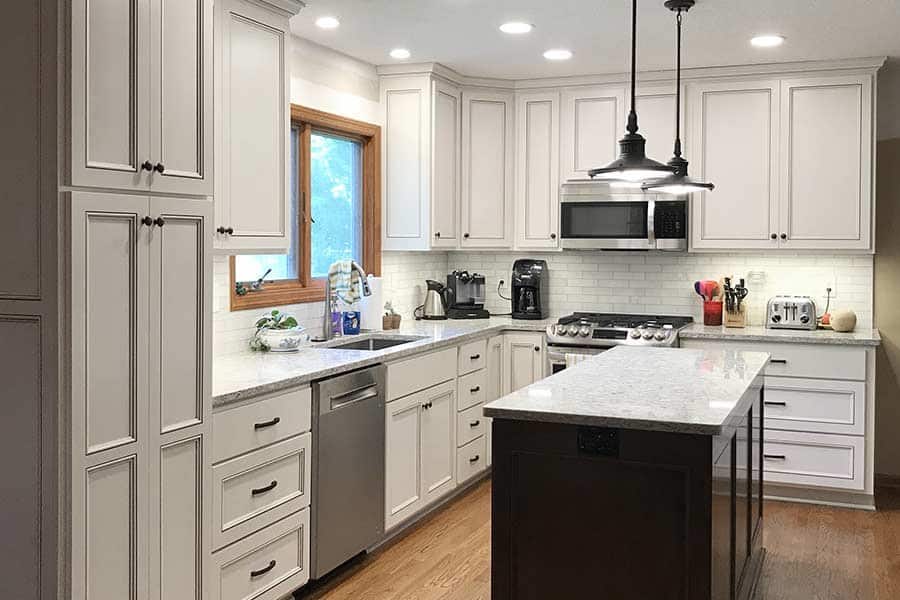 Troyer Transformations website design: one of the kitchen photos on the site, a white kitchen with a black island and a pendant light