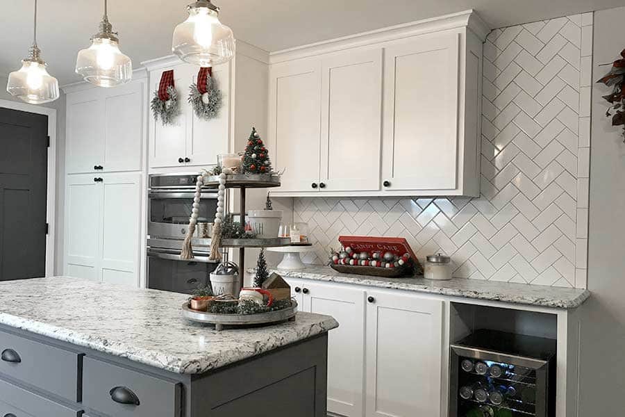 Troyer Transformations website design: one of the kitchen photos on the site, a white kitchen with a gray island and herringbone tile