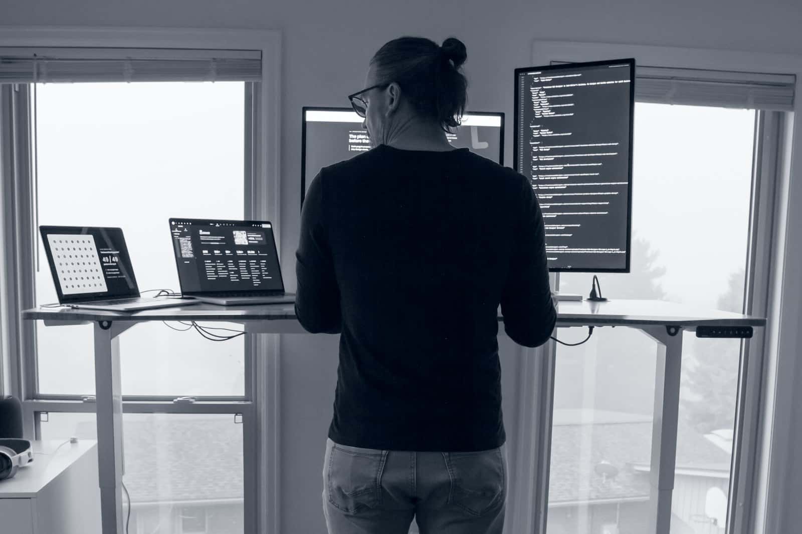 Josh Miller working through the website design process at his standing desk by a wall of windows