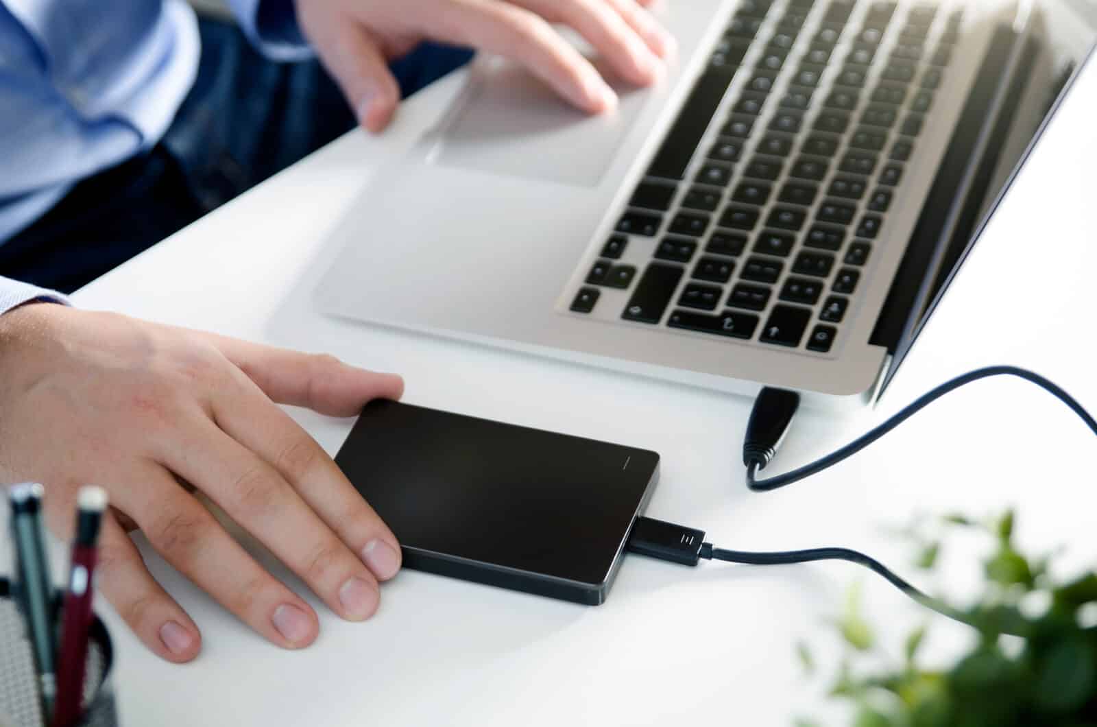 Website maintenance: an external backup drive connected to a laptop