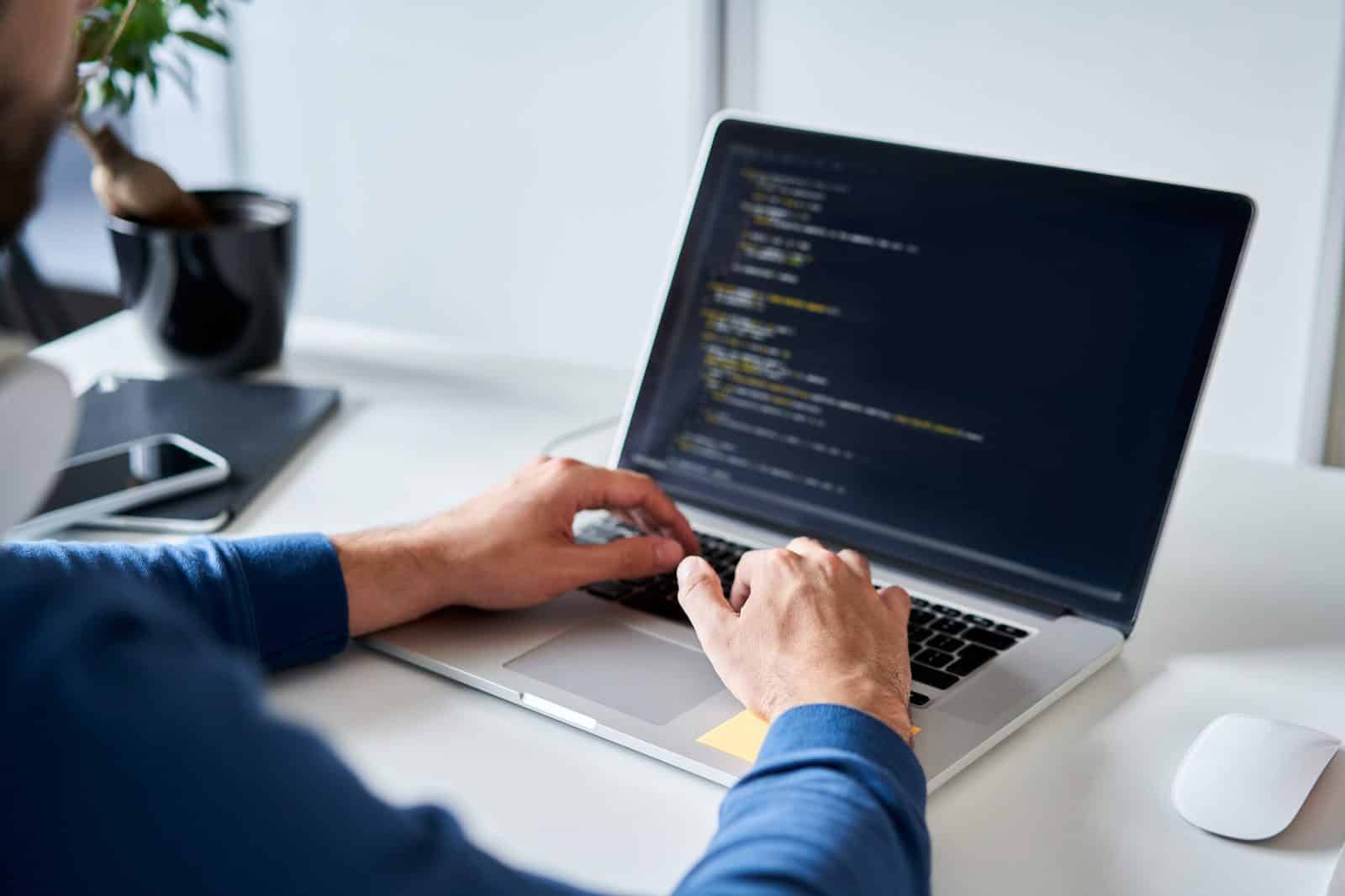 Website repair: hands typing code on a laptop